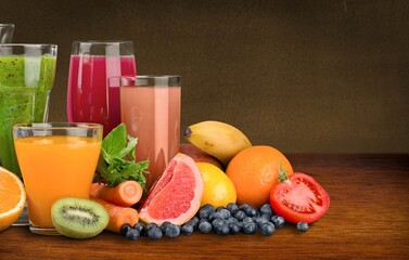 Composition of fruits and glasses of juice on desk