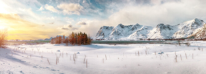 Winter scenery with frozen fjord on Vestvagoy island at sunset with snowy  mountain peaks near Valberg