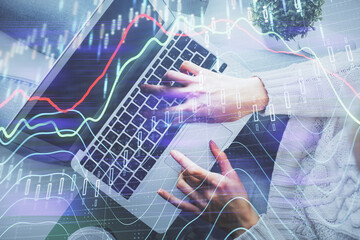 Double exposure of woman hands working on computer and forex chart hologram drawing. Top View. Financial analysis concept.