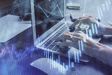 Double exposure of woman hands typing on computer and forex chart hologram drawing. Stock market invest concept.