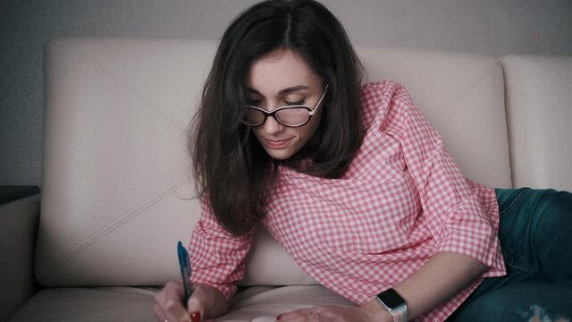 woman writing notes for her distance learning