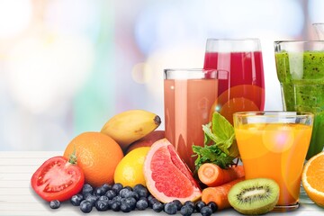 Fototapeta na wymiar Composition of fruits and glasses of juice on desk