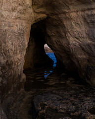 cave on a rock with the water appearing on the other side 