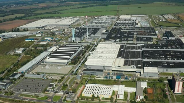 Contemporary factory with car parking. Industrial complex among green fields. Huge area of manufacturing near the road in countryside. Aerial view. bratislava.