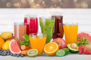 Composition of fruits and glasses of juice on desk