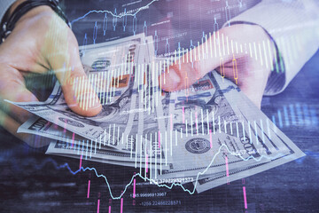 Multi exposure of financial graph drawing hologram and USA dollars bills and man hands. Analysis...