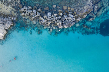 An aerial view of the beautiful Mediterranean Sea, where you can see the cracked rocky textured underwater corals and the clean turquoise water of Protaras, Cyprus,	
