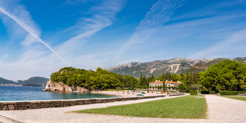 Picturesque panorama of Milocer Plaza the king's luxurious beach in Przno village, Montenegro. Tiny beach with massive moutnains in the background.