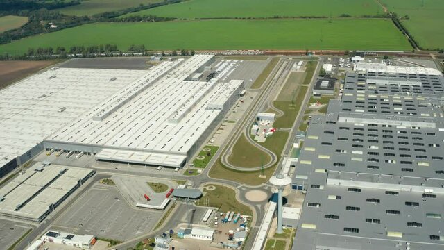 Contemporary factory with car parking. Industrial complex among green fields. Huge area of manufacturing near the road in countryside. Aerial view. bratislava.