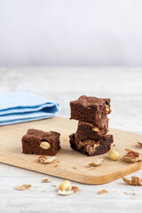 Selective focus to pieces of chocolate brownie with peanuts on a wooden board. Copy space.
