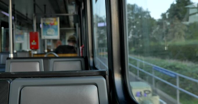 Selected focus view at seat on the moving Light rail tram arrival platform with street view of countryside of Germany through window. Enjoy moment during commute and travel by Tram in Europe.