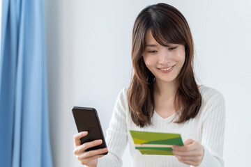 スマートフォンで銀行口座を確認する女性