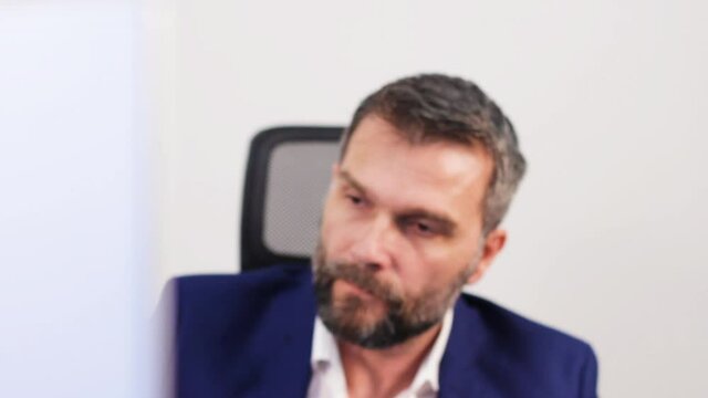 Nervous Investment Banker in Office Looking at Computer Screen With Stock Prices Picking Up Phone. Close Up Static Full Frame