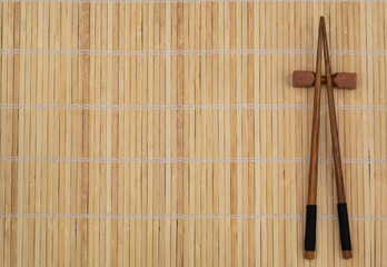 Wooden chopsticks on bamboo place mat with copy space