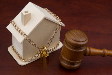 Locked house and judge gavel, law and real estate concept