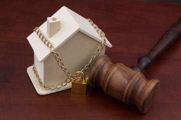 Locked house and judge gavel, law and real estate concept