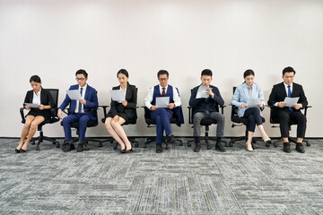 group of asian businesspeople waiting in line for job interview