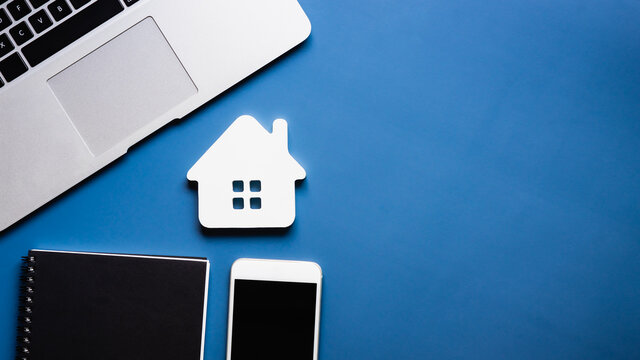 Computer keyboard, note book, mobile phone and house model Real estate agent offer house, property insurance and security, affordable housing concepts.