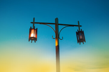 Old and vintage lamps on the pillars. It is shining in the evening