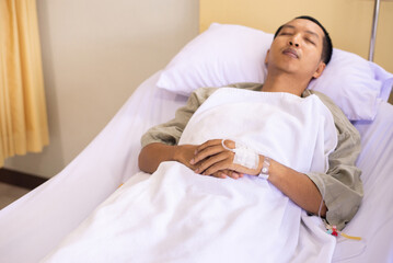 Patient Asian man sleeping under blanket on sick bed at the hospital