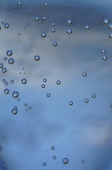 Air bubbles in a glass of water, blue and light graphite, close-up - obrazy, fototapety, plakaty