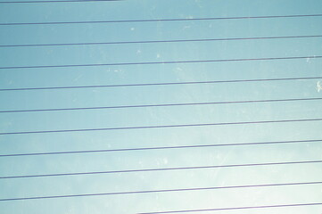 Thin dark lines on a background of blue sky. - obrazy, fototapety, plakaty