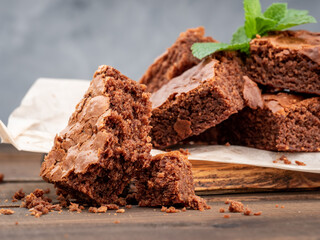 Brownie cookies lie on the board, in the background a glass with milk.