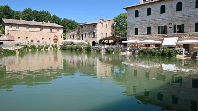 Bagno Vignoni, Tuscany, Italy. August 2020. View of the water mirror of the spring basin: here thermal water flows which fills the rectangular basin. Pan footage. Nice sunny day.