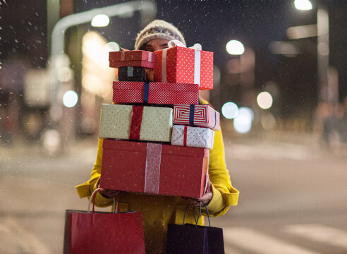 Woman Carrying Pile of Christmas Gifts