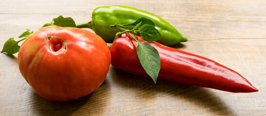Banner with red tomato, and red and green bell peppers on wooden background. Healthy food concept