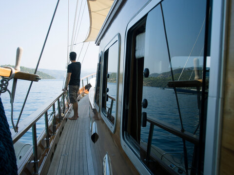 Man standing on the deck of a sailing boat.