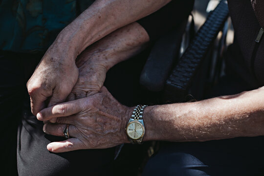 Wrinkled seniors hands holding hands