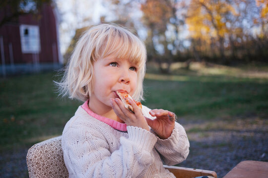 Young girl enjoying her pizza for lunch.