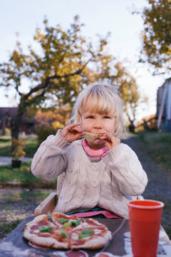 Young girl enjoying her pizza for lunch.