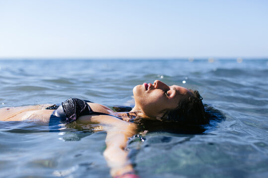 Woman relaxing on the blue sea in a sunny summer day.
