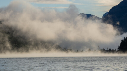 Maloja mountain Pass, Switzerland. Landscape of the lake Sils in the morning during the fall time. The fog covers the lake and the shores. Traditional Swiss contest. Natural landscape