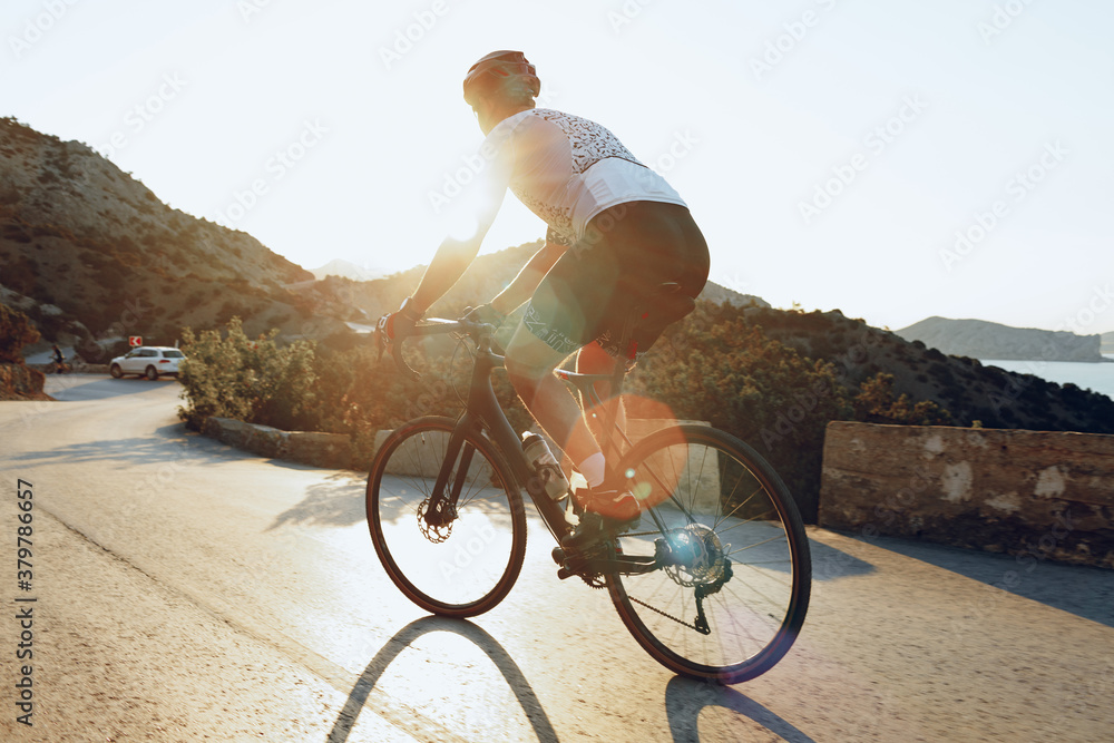 Wall mural cycling sport athlete man riding on coastal road