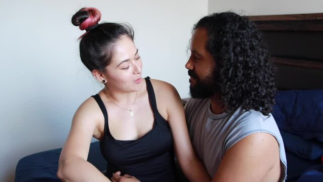 Pareja de j&oacute;venes platicando en la ma&ntilde;ana en cama dentro de casa