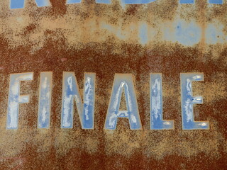 Finale text on rusty metal surface