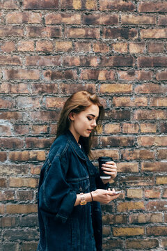 Beautiful Young Woman with a Coffee and a Mobile phone