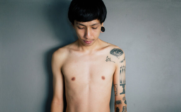 Asian young man with tattoo on his shoulder