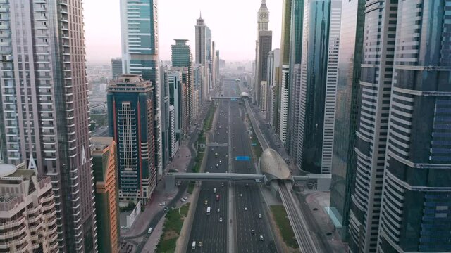Aerial view of morning rush hour traffic on Sheikh Zayed Road, with cars and metro trains between high rise buildings and skyscrapers