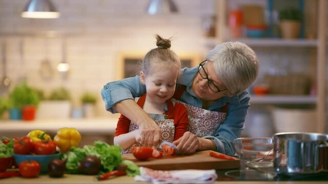 Healthy food at home. Happy family in the kitchen. Grandma and child are preparing the vegetables.
