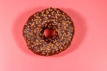 Tasty chocolate donut on a pink background