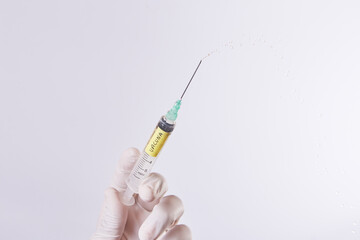 Mano de hombre con guantes sostiene una Inyección  con vacuna en fondo aislado. 