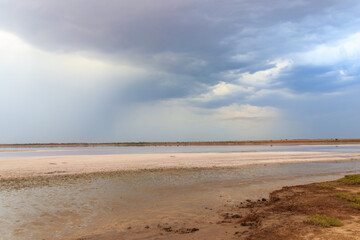 Fototapeta na wymiar Dark storm clouds over a salt lake before a rain