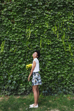 Smilingl girl holding a bouquet of yellow flowers