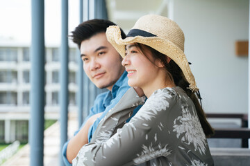 Couple traveler standing on hotel balcony looking at the view.