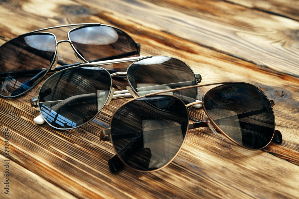 Sticker set of dark sunglasses on brown wooden surface