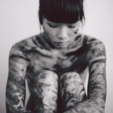Blurry image of young beautiful Asian woman with messy paint on the body